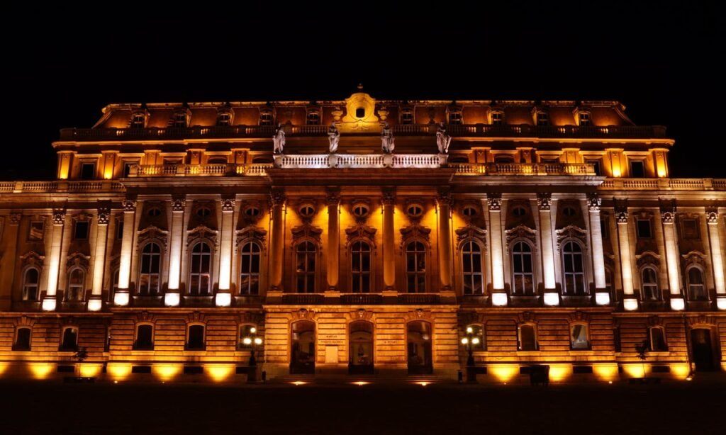Night view of the beautifully illuminated Buda Castle, an iconic landmark in Budapest, Hungary.