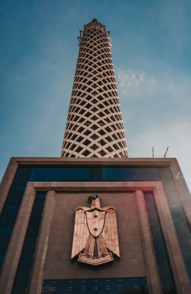 A low angle shot of the Cairo Tower in Egypt, showcasing modern architecture and structural design against a clear blue sky.