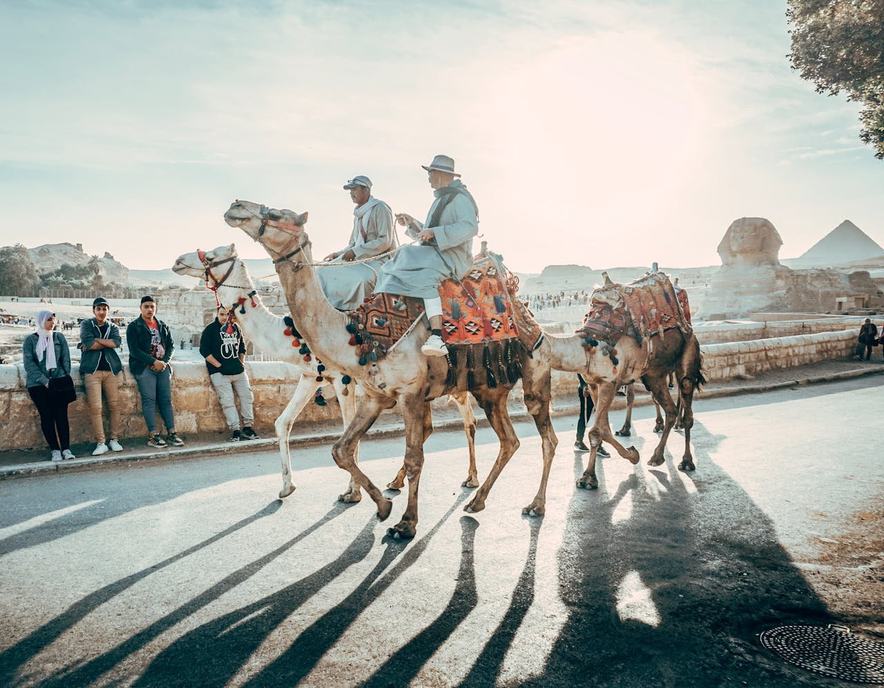 Camel riders in traditional attire at the Great Sphinx of Giza in Cairo, Egypt.